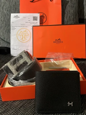 Svart Hermès skärp i skinn - Exklusivt svart skärp från Hermès i äkta skinn med den ikoniska H-spännet i silverfärg. Klassisk och stilren design som passar till många olika looks. Levereras i originalförpackning med tillbehör.