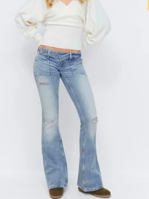Ljusblå bootcut jeans med slitningar - Säljer ett par ljusblå jeans med några slitningar på lår och knän, low waist. Nya med prislapp, helt oanvända och endast provade. Längd: Regular 