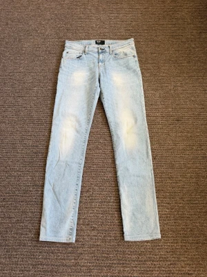 Jeans - Säljer ett par ljusblå jeans från Big Star med raka ben och klassisk femficksmodell. Jeansen har en snygg tvätt med slitningar på låren och knäna. Tillverkade i bomull för en skön och avslappnad look.