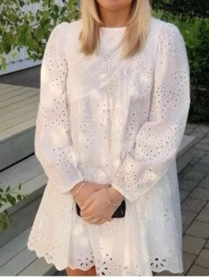 Vit broderad kortklänning - Söt vit kortklänning med broderade detaljer och långärmad design. Klänningen är 13-14 åringar men är som en xs 