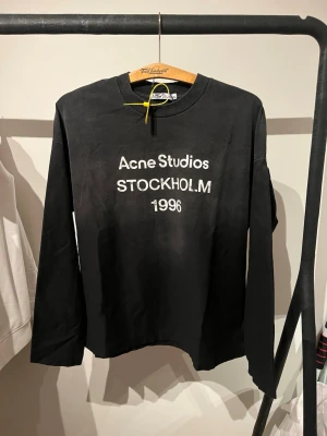 Svart långärmad tröja Acne Studios - Svart långärmad tröja från Acne Studios med vit text 'Acne Studios STOCKHOLM 1996' på bröstet. Tröjan har rund halsringning och är jätte bra skick. Som ni ser på bilden är den lite baggy och jag är 168 lång. MVH Larre 