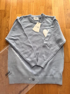 Stickad Ami Paris tröja  - Helt ny stickad ljusblå/babyblå Ami Paris tröja, extremt skönt 👌.Inga skador eller missfärgningar. Tag sitter kvar. Skriv vid frågor eller funderingar. Pris går att förhandla. Skickar snabbt 📦🚚💨