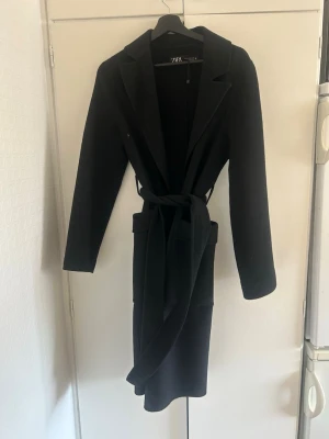 Svart kappa med knytskärp från Zara - Stilren längre svart kappa från Zara 