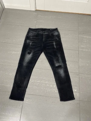 Svarta dondup jeans med slitningar - Lite schystare Dondup jeans. W33. Midja 42 cm + Längd 92 cm. Nypris 3499. Mycket bra skick, inga defekter. Väldigt sällsynta jeans och svåra att få tag i🙌