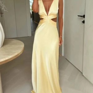 Lång ljusgul satinklänning med knyt - Balklänning från that’s so fetch. Kostar 750kr pluss tullavgift så typ 1000kr. Inga tecken på användning. 