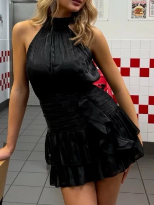 Svart omlottklänning med volanger - Jättefin trendig svart klänning i lite glansigare tyg. Från meet me there. Helt ny och oanvänd med prislapp kvar. Kan självklart skicka bilder på den privat☺️Storlek xs/xxs. Pris kan diskuteras💕