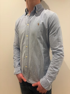 Ljusblå Ralph lauren skjorta - strl M - Ralph Lauren skjorta 👔✨ Ljusblå och stilren 💙 Storlek M 👀 Snygg passform som funkar både uppklätt och mer avslappnat 😎🔥 Klassisk och tidlös design Kolla in profilen för flera feta Ralph Lauren skjortor 👀🔥 Hör av er om ni har frågor eller vill ha fler bilder 💬