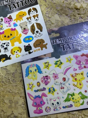 Söta temporära tatueringar djurmotiv - Två ark med temporära tatueringar med färgglada och gulliga djurmotiv, bland annat hundar, katter, kaniner och fantasidjur. Perfekt för att piffa upp din stil med lekfulla och kreativa detaljer. Lätta att applicera och ta bort. 3 år + 