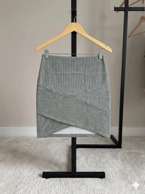 Grå  kjol från Gina Tricot - Säljer en grå  kortkjol från Gina Tricot. Kjolen har en snygg passform. I fint skick. Storlek S