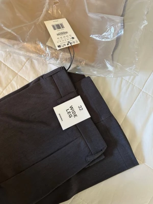 Mörkgrå wide leg tailored Bershka - Helt nya kostymbyxor i storlek 32! Etiketterna sitter fortfarande kvar och byxorna är aldrig använda. Hör gärna av dig vid frågor!🌷
