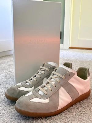 Maison margiela gats - Säljer ett par riktigt fina maison margiela skor 👟 , skorna är nästan helt nya använts fåtal gånger och är i riktigt bra skick🙌🏻 skorna är i stl 43 men skulle säga att fom sitter lite mindre så passar också 42👏, pris är ej hugget i sten 🪨kom med bud/frågor vid det minsta📬