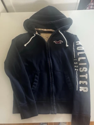 Hollister California zip hoodie mörkblå  - Riktigt snygg och eftertraktad Hollister zip hoodie. fint skick inga fel storlek L kan passa M kan ta mått vid behov. Endast 400kr  kom gärna med frågor och prisförslag har även mycket mer liknande i min profil alla storlekar kolla gärna stor rabatt vid köp av flera 😁✌️