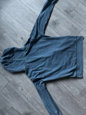 Blå hoodie från Polo Ralph Lauren - Snygg blå hoodie från Polo Denim & Supply Ralph Lauren. Klassisk modell med huva och mjukt material på insidan. Perfekt för en avslappnad och cool stil. Inga tryck eller mönster, bara enkel och stilren design.