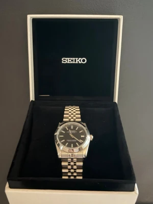 Seiko datejust 36mm carbon black - Seiko automatisk klocka som endast är använd vid 1 tillfälle! 36mm perfekt för dig med lite mindre handleder. Sätter priset ganska lågt så skambud svarar jag inte ens på! Obs boxen på bild 1 medföljer ej men skickar säkert i en annan klockbox med alla tillbehör som medföljde 🙌