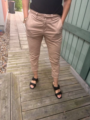 Beige lågmidjade chinos - Snygga beige chinos. Tillverkade i ett mjukt och lätt material som ger en clean och stilren look. Perfekta för dig som gillar en avslappnad men ändå dressad stil.
