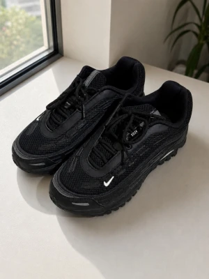 Nike x Comme des Garçons Air Max TL 2.5 - Svarta Nike x Comme des Garcons Airmax TL 2.5 sneakers i samarbete med Comme des Garçons Homme Plus. Skorna har mesh och läderdetaljer, klassisk Air Max-sula och små vita Swoosh-loggor. Texten 'COMME des GARÇONS HOMME PLUS' syns på hälen. Grymt stilrena och unika sneakers. SIZE 40 EU