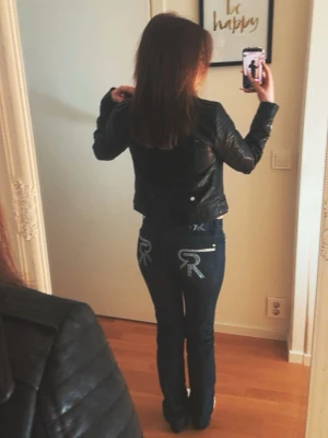 Mörkblåa jeans från Rock & Republic - Säljer ett par as snygga mörkblåa jeans från Rock & Republic med raka ben och snygga broderade detaljer i silver och glitter på bakfickorna. Jeansen har låg midja och är i storlek 24, inte särskilt stretchiga. Jag köpte dom i en secondhand butik för 800 kr, för ca 1 år sedan. Jeansen har inte använts mycket av mig och är iprincip nyskick.