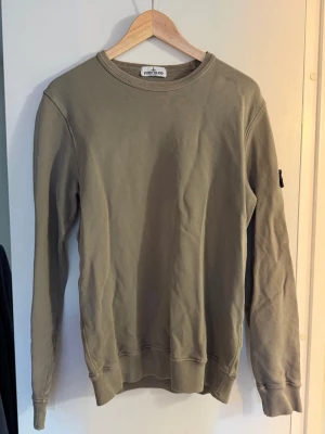 Stone island sweatshirt  - Stone island sweatshirt i superfin grön färg!💚 Slitage längst ner på ena ärmen men går att sy ihop🌟🌟 Storlek 170/14år