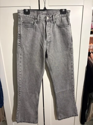 Grå jeans från Dr. Denim - Säljer ett par gråa jeans från Dr. Denim med rak passform och klassisk femficksdesign. Jeansen har normal midja, bälteshällor och är tillverkade i ett mjukt denimtyg. Perfekta för en avslappnad och trendig look.