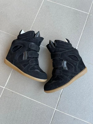 Isabel Marant - Authentic Isabel Marant wedge sneakers in black, size 39.  Excellent condition with very little wear. Clean soles and well maintained. A timeless Isabel Marant model that adds height while remaining comfortable for everyday wear.  • Size: EU 39 • Color: Black • Hidden wedge heel • Very good condition • 100% authentic  Perfect for anyone looking for a stylish designer sneaker that works with both casual and dressed-up outfits.  Message me for more photos or any questions.