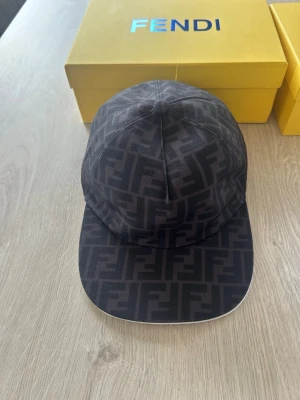 Svart fendi keps  - Fendi-keps i svart – Helt ny! 🔥  Säljer en stilren och exklusiv svart Fendi-keps i mycket snygg design med det klassiska FF-mönstret. Kepsen är helt ny och i toppskick.  ✔ Justerbar storlek – passar de flesta ✔ Bekvämt material med hög kvalitet ✔ Tidlös och exklusiv design ✔ Perfekt för både vardag och finare tillfällen  Pris: 900  OBS: Kan tänka mig att sänka priset något vid snabb och smidig affär.  Först till kvarn gäller – skicka meddelande vid intresse! 📩