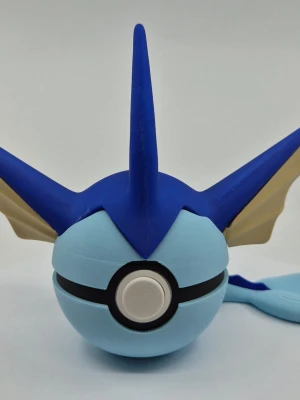 Pokémon-inspirerad pokéboll Vaporeon - Unik pokéboll i plast inspirerad av Vaporeon från Pokémon. Bollen är ljusblå med blå och beige detaljer, spetsiga fenor och en svans baktill. Perfekt som samlarpryl eller dekoration för Pokémon-fans.