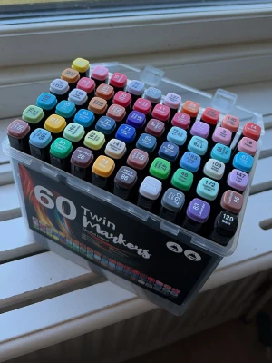 60-pack Twin Markers i plastlåda - Säljer ett set med 60 Twin Markers, Pennorna har dubbla spetsar. Använda ca 3 gånger