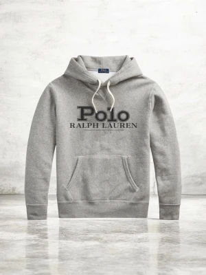  Ralph Lauren Hoodie  - Snygg grå hoodie från Polo Ralph Lauren med stor logga framtill. Klassisk känguruficka, justerbar huva med vita snören och mjukt material som känns skönt mot huden. Perfekt för en avslappnad och stilren look.