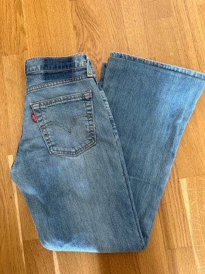 Bootcut/ flare lowwaist levis jeans - Levi’s jeans med låg midja (low rise/low waist). Bootcut/flare-modell med utsvängda ben. Kan beskrivas som bootcutjeans, flarejeans, utsvängda jeans, lågmidjade jeans. Uppsydda av skräddare ca 3-4 cm men kan sprättas utan anmärkning. Passar på mig som brukar ha XS i midjan.  En liten missfärgning vid knät (se bild 2) samt en liten fläck ca 1 cm under bakfickan(se sista bilden) Inget som syns när de är på, då missfärgningen är väldigt diskret och fläcken hamnar i vecket på bakfickan. Inga hål.