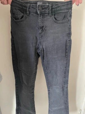 Mörkgrå jeans från Cubus  - Snygga mörkgrå jeans från Baily(cubus) i storlek 146 med klassisk femficksmodell och smal passform. Jeansen har bälteshällor, knappgylf och är tillverkade i ett stretchigt denimtyg för extra komfort. Säljer för att kommer ej till användning. Skriv om du har frågor eller vill ha mer bilder!
