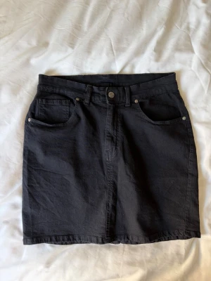 Svart jeanskjol - Svart jeanskjol från dr.denim som är i väldigt skönt och stretchigt material ✨ har en slits på baksidan! 