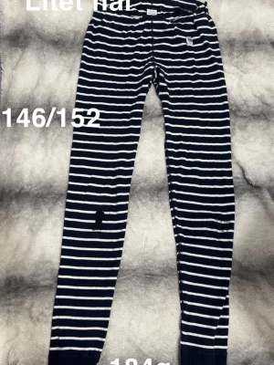 Marinblåvita randiga leggings - Leggings med marinblå och vita horisontella ränder. Perfekta för dig som gillar klassiska ränder och bekväma plagg.🌸 Två fula lagningar och ett litet hål. Storlek 146/152 