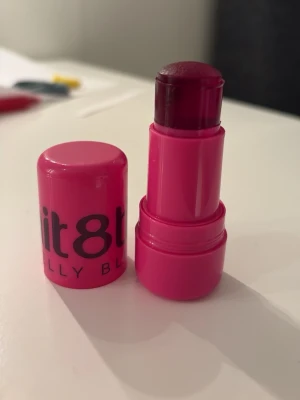 Jelly blush  - Snygg rosa jellyblush från imit8tion. Jelly med en glansig finish. Hylsan är i starkt rosa plast och själva stiftet har en djup bärig ton. Perfekt för dig som vill ha färg och glans i ett. Enkel att ta med i väskan tack vare den kompakta designen. Kan använda för både läppar och kinder! Endast använd 1 gång på min hand.