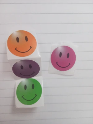Färgglada smiley-klistermärken - Säljer ett gäng runda klistermärken med glada smileys i orange, lila, grön och rosa/magenta. Alla fyra klistermärken för 20 kr.