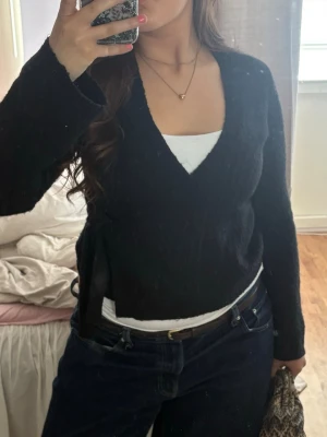 Svart omlottstickad tröja gina - Svart stickad omlott-tröja med långa ärmar och v-ringning från gina i storlek m🫶 skriv ifall du har några frågor! Priset kan diskuteras 💖🫶