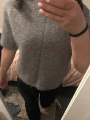 Grå stickad t-shirt - Säljer en enkel och stilren grå stickad t-shirt med korta ärmar och rund hals från Gina i storlek xs då jag inte använder den längre!