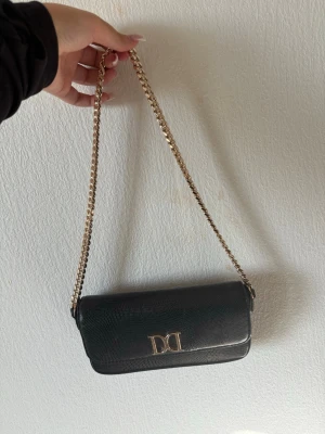 Svart axelväska med kedja från Don donna  - Snygg svart axelväska från glitter 