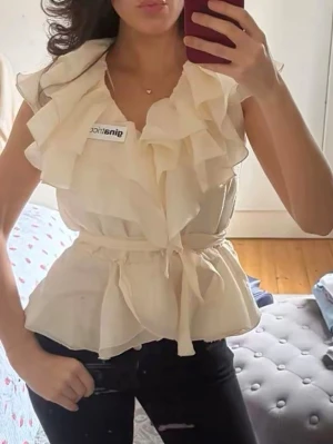 Super fin blus från Gina - En aldrig använd helt ny frill top från Gina med ett skärp 
