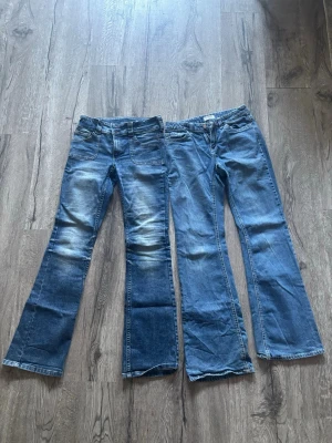 Två par bootcut jeans i blå denim strl 170 - Säljer två par bootcut jeans i klassisk blå denim. Ena paret har slitningar och ljusare partier framtill, det andra är mer jämntvättat. Båda har fickor bak, varav ett par har kontrastsömmar på fickorna. Ena paret från HM och andra från Lindex
