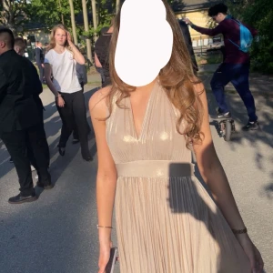 Champagnefärgad långklänning med v-ringning - Säljer min balkläning. Elegant och super fin o efterfrågad. Jag köpte den för 3000. Den är speciell sydd hos skräddare för att den var för stor. Jag är 164 och den är längre på mig så man kan ha klackar alltså passar den flera längder. Jag är vanligtvis en xs/s. Skriv vid frågor. Kan mötas upp!!