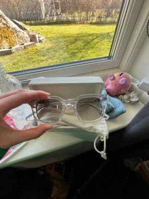 Chimi  - Säljer ett par trendiga solglasögon från chimi med transparenta bågar och gråtonade glas. De har en fyrkantig form och kommer med ett vitt fodral och skyddspåse. Perfekt för dig som vill ha en stilren och modern look.