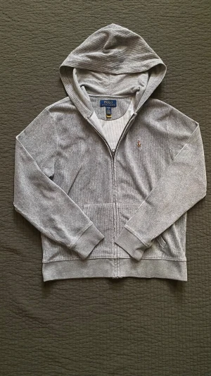 Grå zip hoodie från Polo Ralph Lauren - Säljer denna ralph lauren hoodien då den är lite för liten | väldigt bra skick och inga defekter | storlek 14-16 så en xs ungefär (jag på bilden är 170)