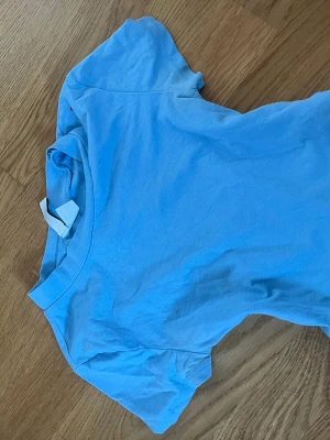Ljusblå basic t-shirt från H&M - En ljusblå t-shirt från Divided by H&M i mjuk bomull. Storlek xs