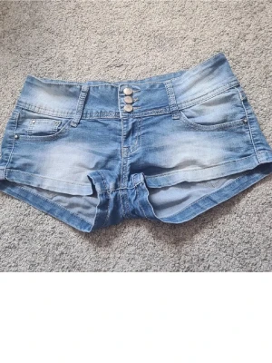 Blå lågmidjade minishorts - Ett par jättefina lågmidjade shorts i superbra skick👌köpta på secondhand, men är knappt använda sen innan. Saknas diamanter vid fickan som syns på bilden👍 Märket är Redress collection, skriv till mig för mer info eller frågor🤗