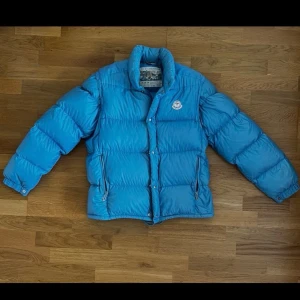 Vintage Moncler Grenoble Jacka/Väst - Säljer en blå pufferjacka från Moncler med avtagbara ärmar så den kan användas som väst. Jackan har hög krage, dragkedja och tryckknappar framtill samt två fickor med dragkedja. Liten fläck på ryggen samt ett litet hål. Priset är absolut diskuterbart vid snabb affär.
