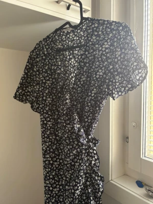 Blommig omlottklänning från ONLY - Fin Svart omlottklänning med vita blommor på🌸Storlek 40🌸Från Only🌸 Passar mig som har M🌸