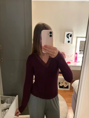 Vinröd långärmad topp med spets - Vinröd långärmad topp med v-ringning och fina spetsdetaljer vid halsen. Sitter tight och har en stilren look som passar perfekt till jeans eller kjol. Enkel men ändå elegant design. Priset kan diskuteras ❣️
