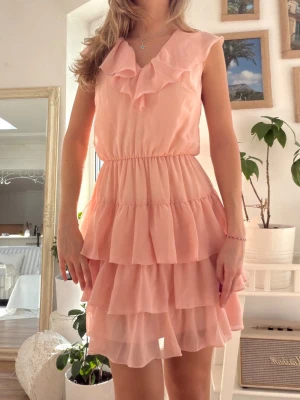 Korallrosa volangklänning   - Storlek 34 (XS). Jag är 165 på bild. Skickas inom 24h. Se liknande plagg i min profil! 