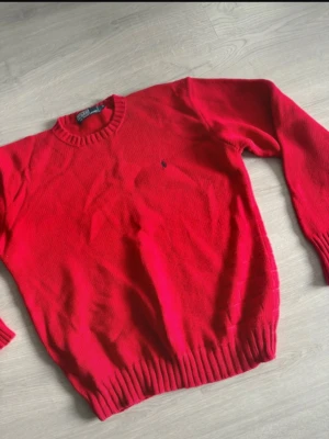 Röd stickad tröja | Ralph Lauren  - Röd stickad tröja från Ralph Lauren i storlek M. Tröjan är i nyskick. Skriv privat för fler bilder eller funderingar!