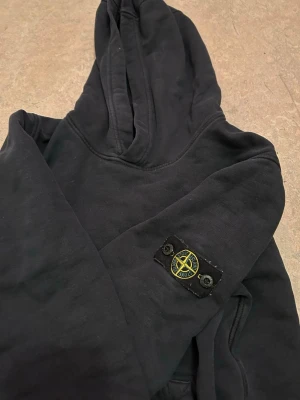 Stone Island hoodie - Svart hoodie från Stone Island med patch på vänster ärm. QR Scan finns! 
